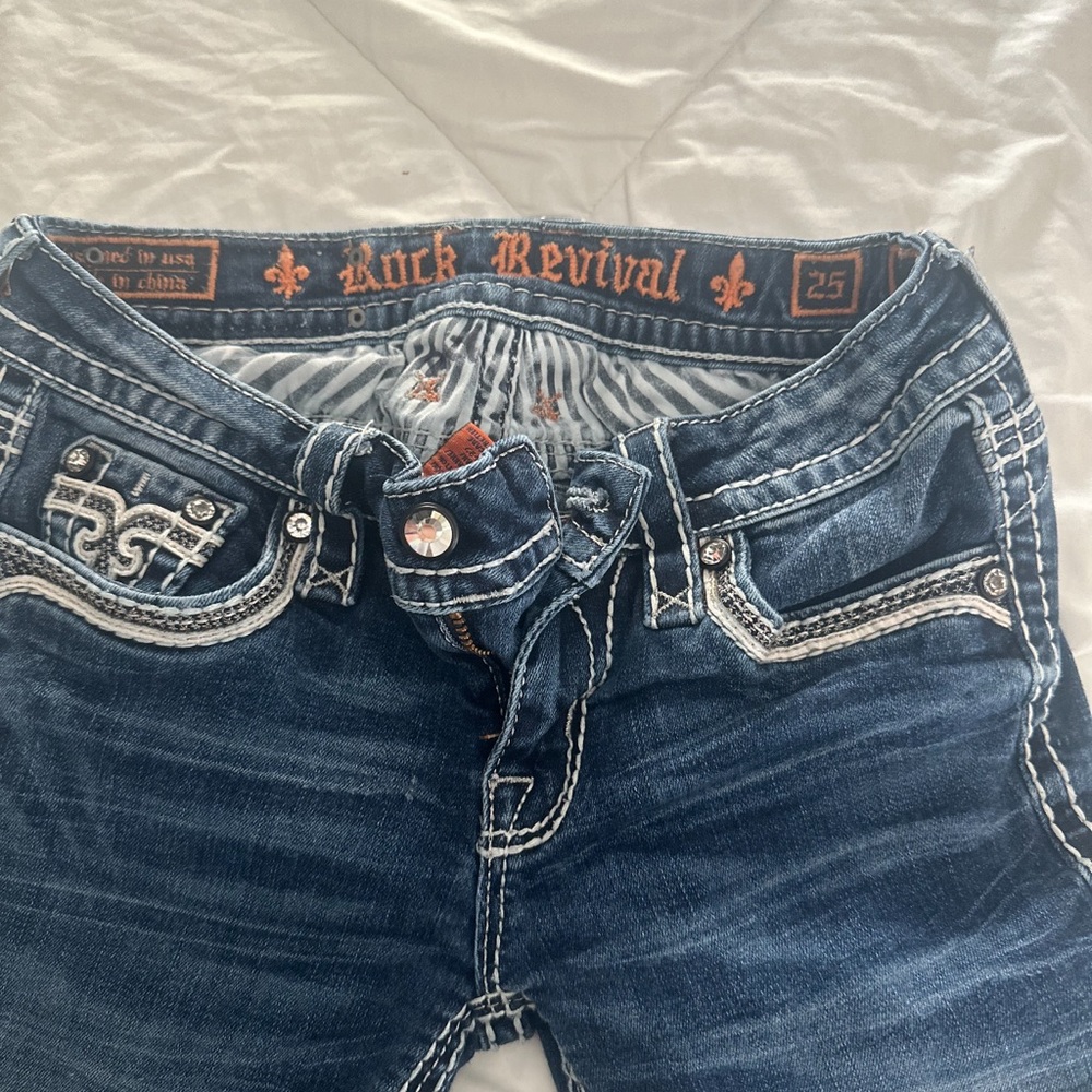 Rock revival blue jeans, style ENA/skinny size 25/30 button back pockets # 02